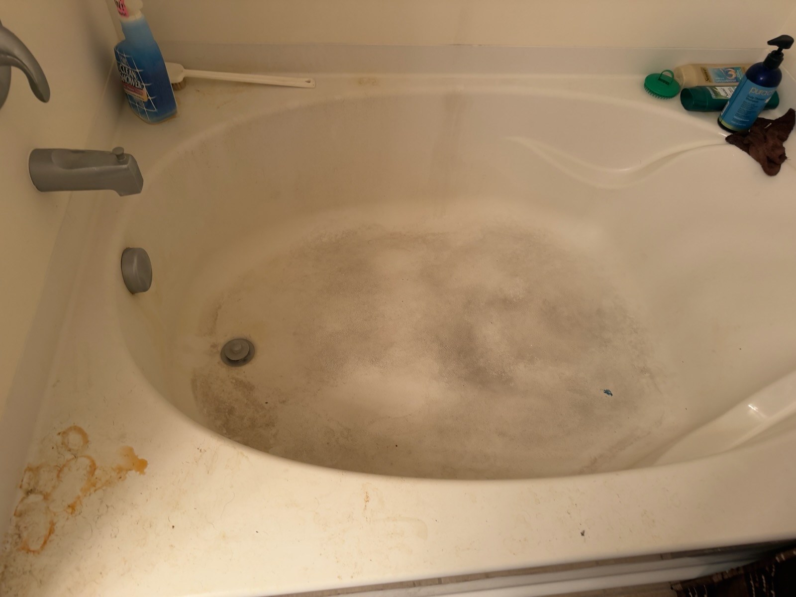 Bathtub with mineral deposits and soap scum before cleaning